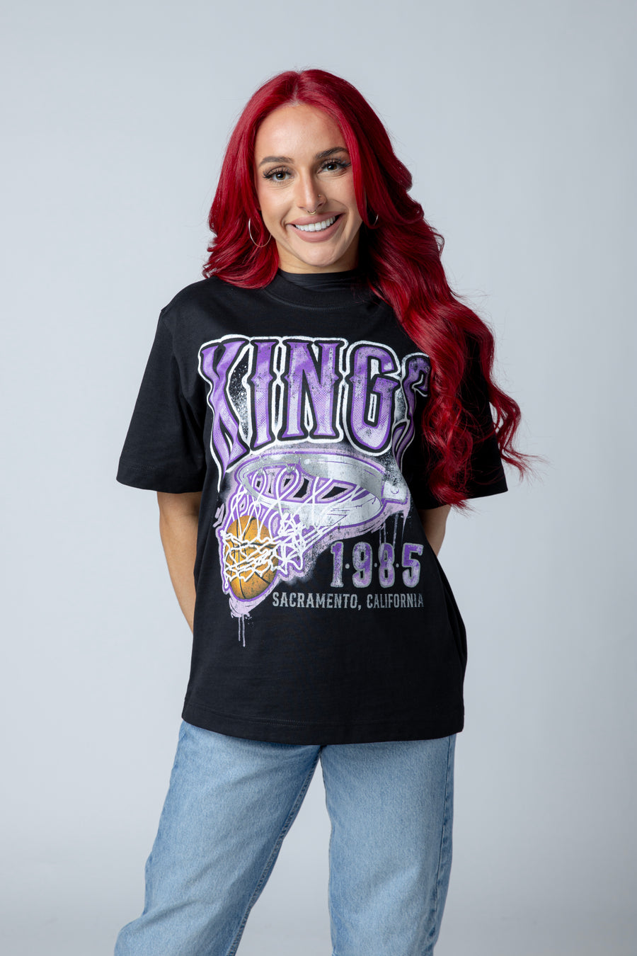 Person wearing a black t-shirt with 'Kings' and 'Sacramento, California' text on a plain background